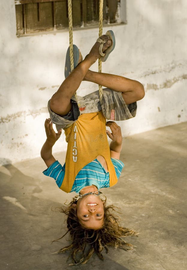 A village boy hanging upside down. 