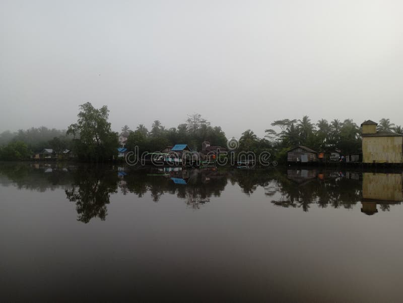 Village residents&x27; houses on the banks of the Mentaya Borneo River, photo taken from the boat in the morning