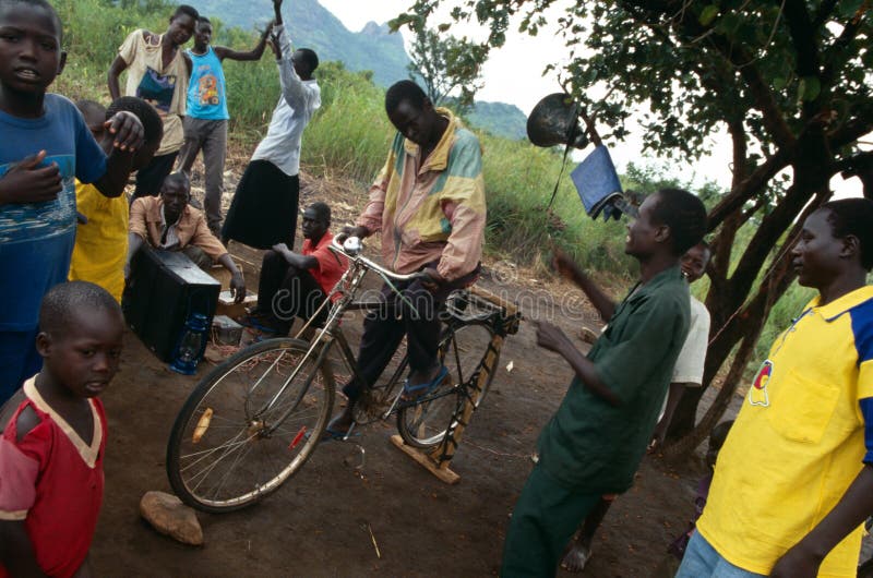 Villagers listening to pedal-powered radio, Uganda