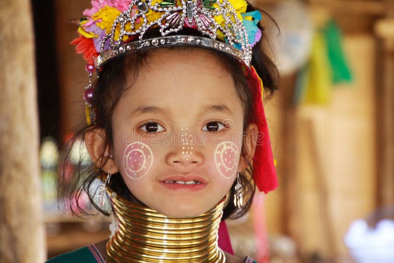 VILLAGGIO DI LONGNECK KAREN, TAILANDIA - 17 DICEMBRE 2017: Il ritratto alto vicino di giovane ragazza lunga del collo con Thanaka immagine stock VILLAGGIO DI LONGNECK KAREN, TAILANDIA - 17 DICEMBRE 2017: Il ritratto alto vicino di giovane ragazza lunga del collo con Thanaka immagine stock
