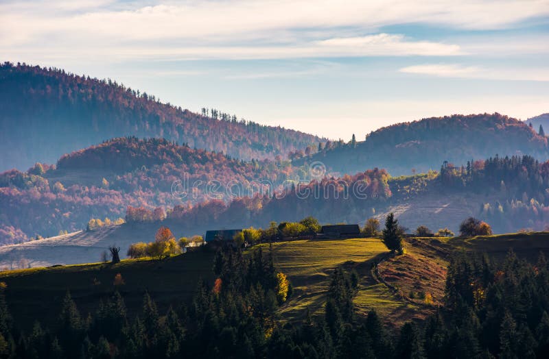 Villaggio sopra una collinetta erbosa in autunno immagini stock Villaggio sopra una collinetta erbosa in autunno immagini stock