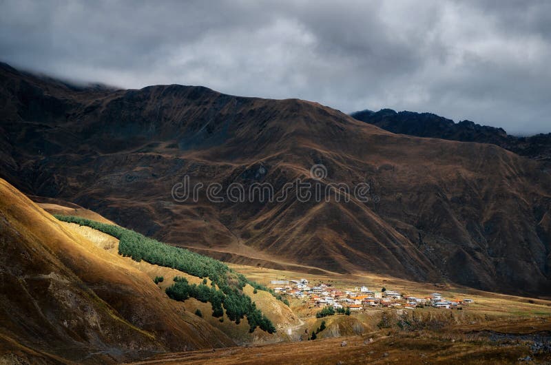 Villaggio sulla collina di maggiori montagne di Caucaso, Kazbegi, Georgia immagini stock libere da diritti Villaggio sulla collina di maggiori montagne di Caucaso, Kazbegi, Georgia immagini stock libere da diritti