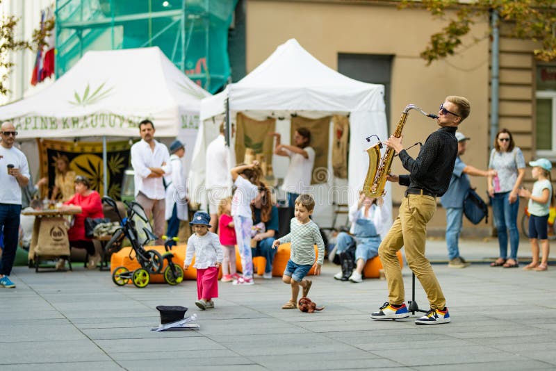 VILNIUS, LITHUANIA - SEPTEMBER 3, 2023: Street musician performing at Nations Fair, where masters from the national communities of Lithuania present their arts, national customs and traditions. VILNIUS, LITHUANIA - SEPTEMBER 3, 2023: Street musician performing at Nations Fair, where masters from the national communities of Lithuania present their arts, national customs and traditions