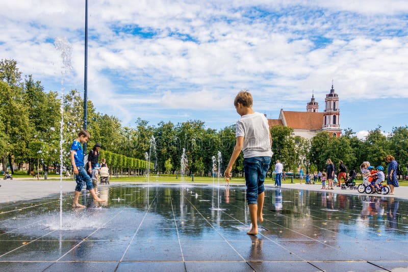 Vilnius Lithuania, July 06 2018: Happy kids have fun playing in city water fountain on hot summer day in Lukiskes square