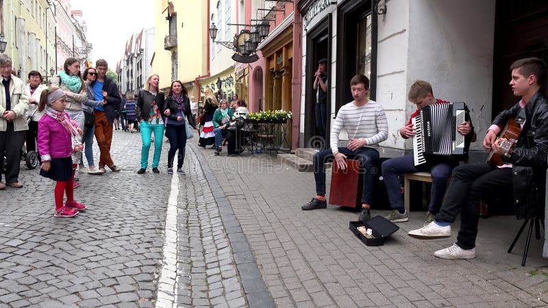 Young boys play musical instruments against people audience. Panorama.