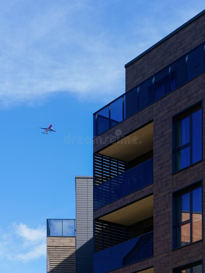 Vilnius, Lithuania - October 1, 2016: Fragment of Modern architecture of residential building. Airplane flies near there royalty free stock image