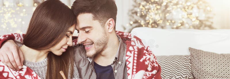 Vin chaud potable aimant de couples contre l'arbre de Noël photographie stock Vin chaud potable aimant de couples contre l'arbre de Noël photographie stock