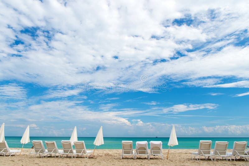 Vind grote waarden in glitzy Zuidenstrand Het zuidenstrand van Miami Sunbeds en paraplu's op zandig strand De Reis van Florida wa stock afbeelding Vind grote waarden in glitzy Zuidenstrand Het zuidenstrand van Miami Sunbeds en paraplu's op zandig strand De Reis van Florida wa stock afbeelding