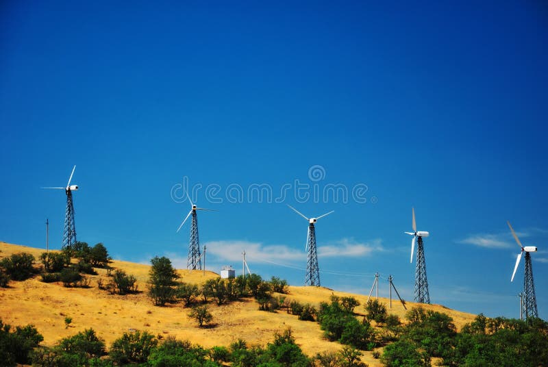 Vindkraftstation mot en klar blå himmel arkivfoton