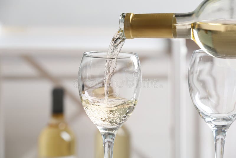 Vinho branco delicioso de derramamento no vidro foto de stock royalty free Vinho branco delicioso de derramamento no vidro foto de stock royalty free