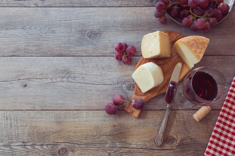 Vinho, queijo e uvas na tabela de madeira Vista de cima com do espaço da cópia