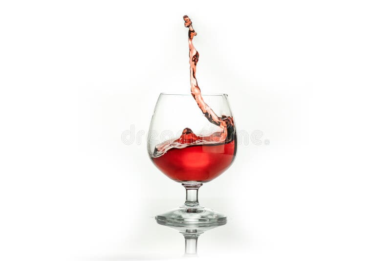 Vinho tinto que espirra fora de um vidro, isolado no branco imagens de stock Vinho tinto que espirra fora de um vidro, isolado no branco imagens de stock