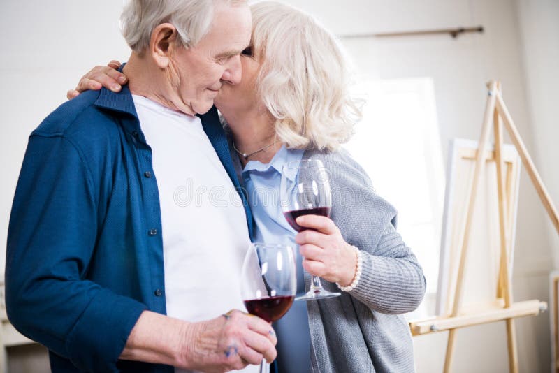 Vino de consumición de los pares mayores sensuales en taller del arte imagenes de archivo Vino de consumición de los pares mayores sensuales en taller del arte imagenes de archivo