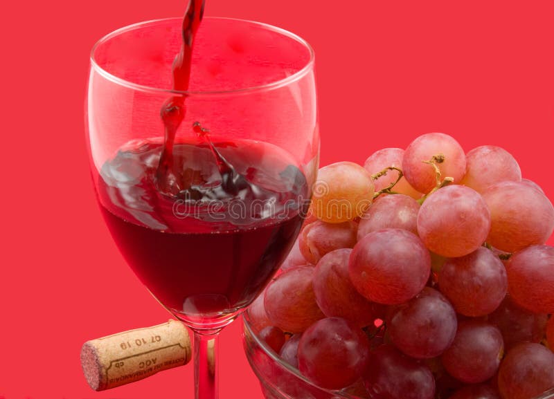 Red wine, red grapes in glass bowl on red background. Red wine, red grapes in glass bowl on red background