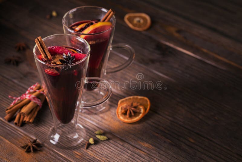 Vino reflexionado sobre con las frutas, los palillos de canela, el anís y las decoraciones imagen de archivo Vino reflexionado sobre con las frutas, los palillos de canela, el anís y las decoraciones imagen de archivo