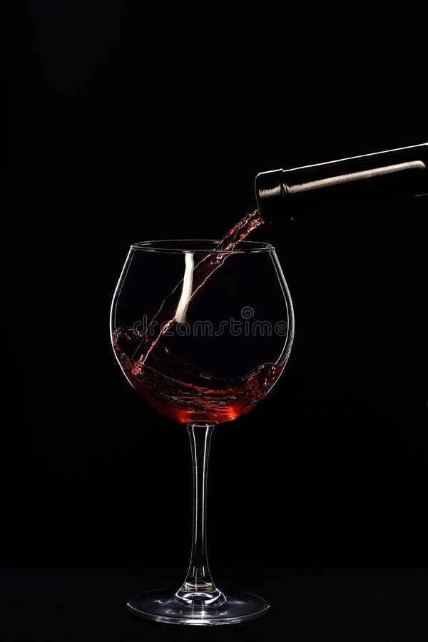 Vino sofisticado vertido del vidrio del embotellado foto de archivo Vino sofisticado vertido del vidrio del embotellado foto de archivo