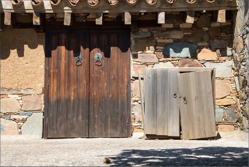 Vintage balcony of an old abandoned house with vintage old wooden door and a stoned clay wall from a traditional house in Cyprus. Vintage balcony of an old abandoned house with vintage old wooden door and a stoned clay wall from a traditional house in Cyprus.