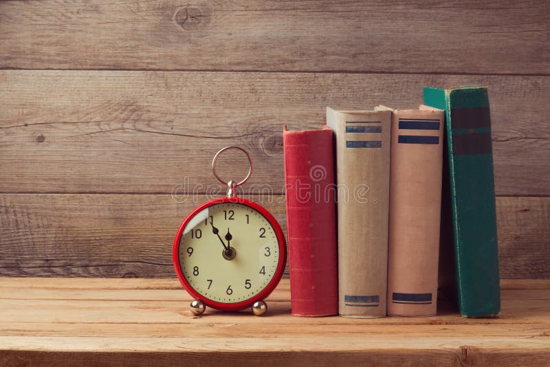 Vintage books and clock on wooden table