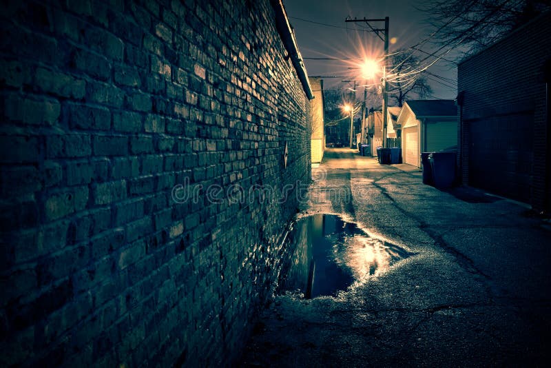 Vintage brick wall in a dark and wet Chicago alley at night.