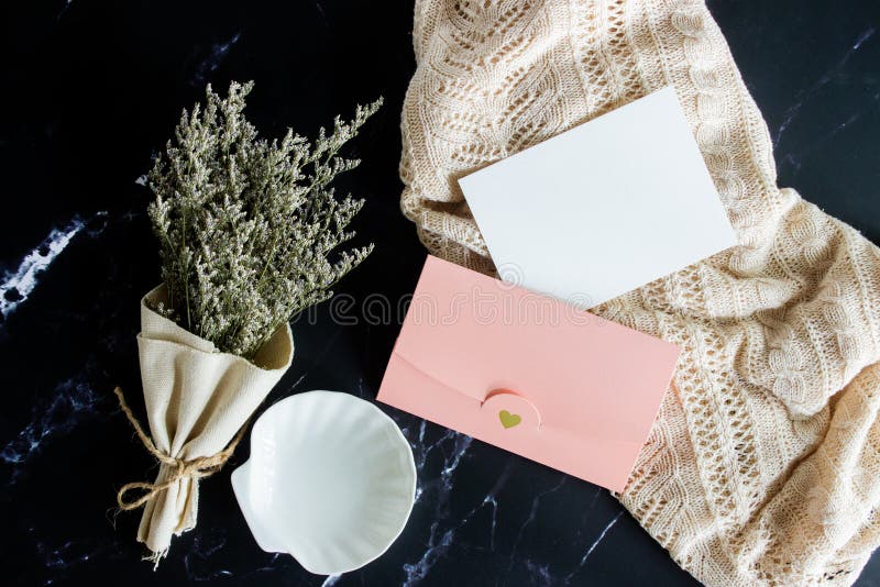 Vintage concept with natural flower, letter and envelope with black marble background. stock photos