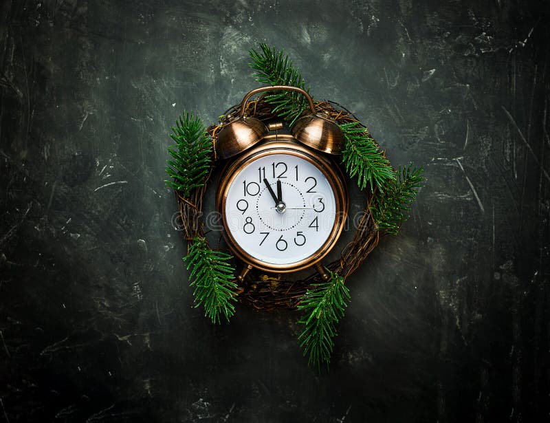 Vintage copper Alarm Clock Five Minutes to Midnight New Years Countdown Christmas Wreath Fir Tree Branches on Black Background stock photography Vintage copper Alarm Clock Five Minutes to Midnight New Years Countdown Christmas Wreath Fir Tree Branches on Black Background stock photography