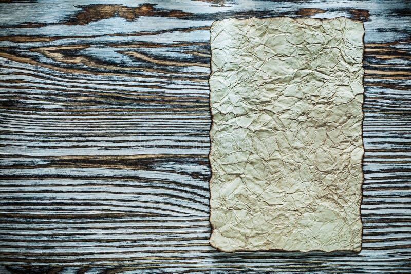 Vintage crumpled parchment on wooden board stock image