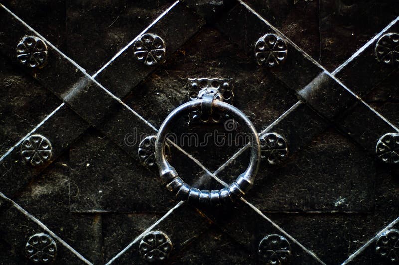 Vintage door handle on a black iron door with forged products, concept of authentic objectsn stock images Vintage door handle on a black iron door with forged products, concept of authentic objectsn stock images