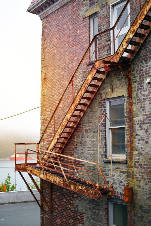 Vintage fire escape stairs on brick building in sunshine stock image Vintage fire escape stairs on brick building in sunshine stock image