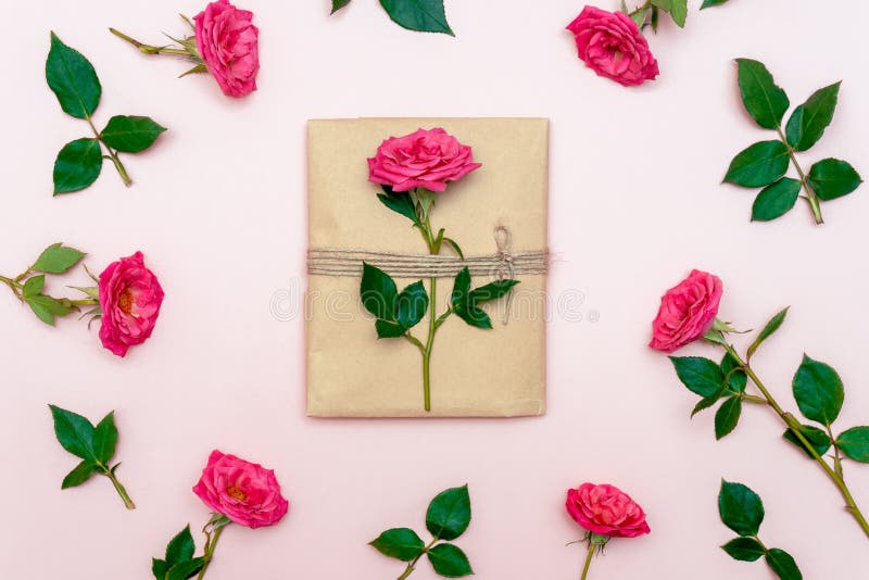 Vintage gift packing in eco paper on soft pink background. Present decorated with rose flowers. Birthday, Mother`s, Valentines, royalty free stock photography Vintage gift packing in eco paper on soft pink background. Present decorated with rose flowers. Birthday, Mother`s, Valentines, royalty free stock photography