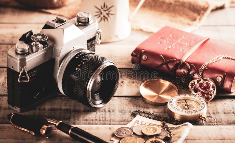 Vintage items, pen red book, coins money, compass and retro photo film camera on wood background stock photo Vintage items, pen red book, coins money, compass and retro photo film camera on wood background stock photo