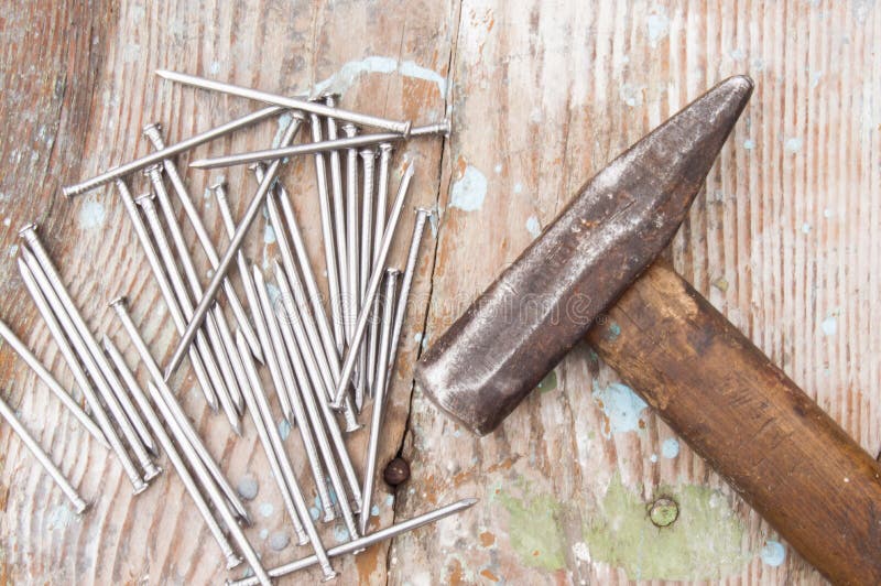 Vintage joiner hammer and nails hobnails lying on old wooden table or workbench with splashes paint on it. Tool master carpenter royalty free stock image Vintage joiner hammer and nails hobnails lying on old wooden table or workbench with splashes paint on it. Tool master carpenter royalty free stock image
