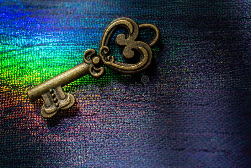 Vintage key. . Antique key. Retro key on on colorful fabric. . Retro key on colorful fabric background.