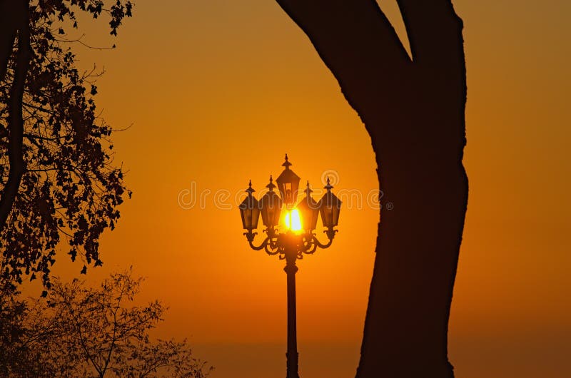 Vintage lantern against sun during sunrise, close-up view. arm natural background of sky. stock photo Vintage lantern against sun during sunrise, close-up view. arm natural background of sky. stock photo
