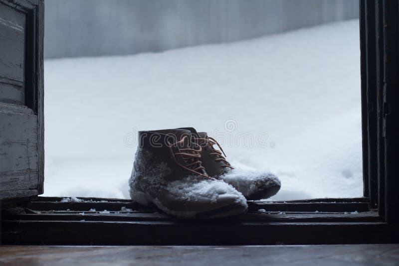 Vintage leather shoes covered in snow by the door