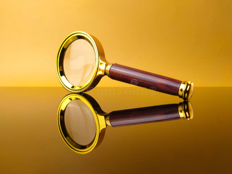 Vintage magnifying glass on yellow background with reflection royalty free stock photography