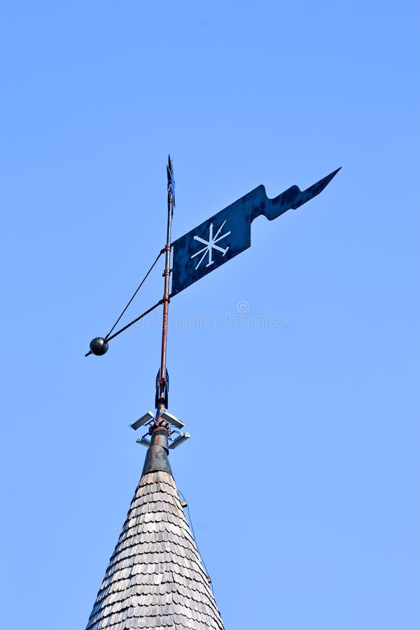 Vintage metal rooftop spire aka spile on the wooden building roof on blue sky in sunny day,, travel diversity