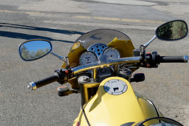 Vintage motorcycle standing on the road. Closeup of motorbike headlight and speedometer royalty free stock photos