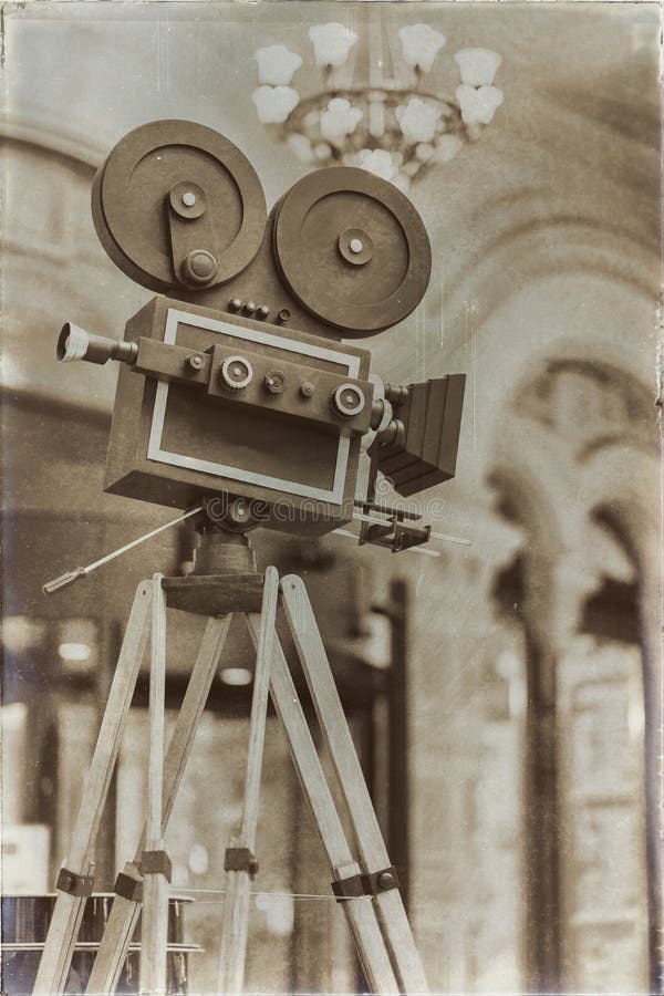 Vintage movie camera on a tripod, model. Processed with retro style. Cinema concept and other antiquities. For royalty free stock photo Vintage movie camera on a tripod, model. Processed with retro style. Cinema concept and other antiquities. For royalty free stock photo
