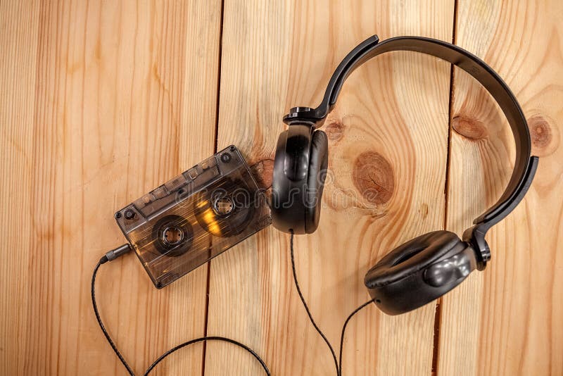 vintage old film music cassette with headphones on a wooden background, music background, music lovers stock photos