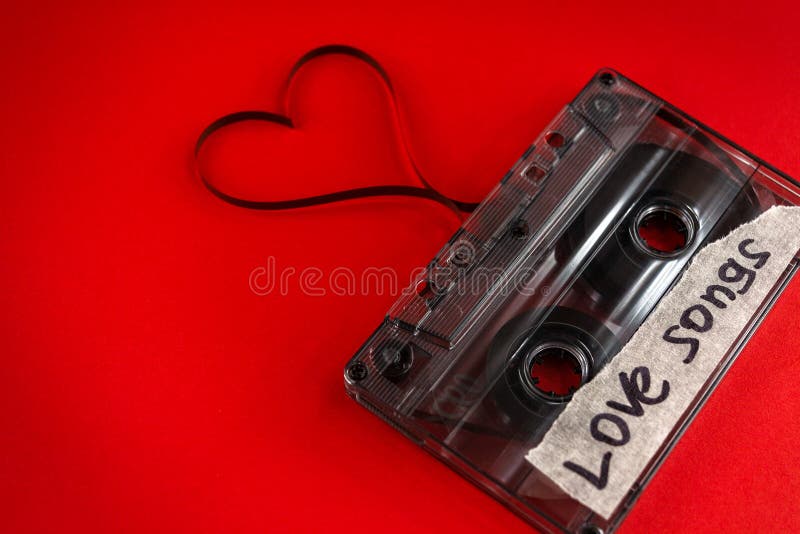 Vintage old film music cassette on a trendy pink red background with the inscription love song, background music, music lovers royalty free stock photography