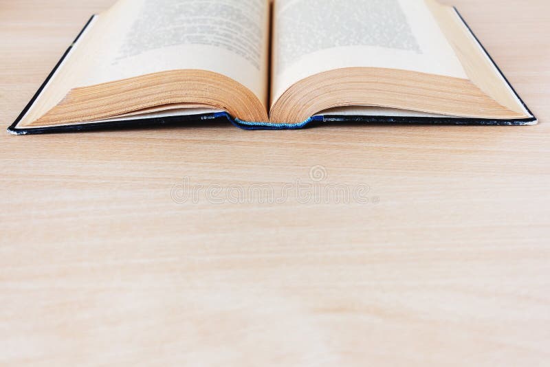 Vintage open boek met pagina's die van tijd tot tijd op een houten tafel worden gegelimiteerd stock foto Vintage open boek met pagina's die van tijd tot tijd op een houten tafel worden gegelimiteerd stock foto