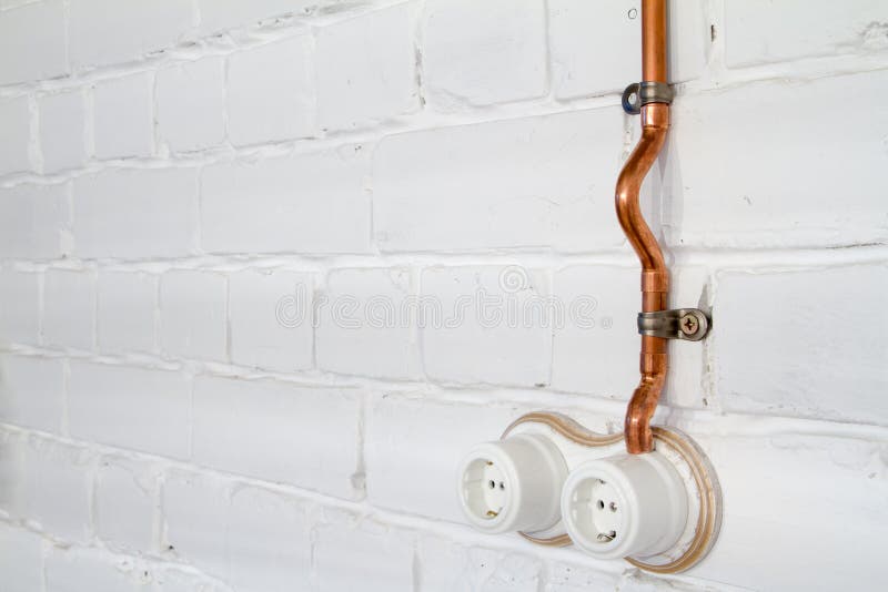 A Vintage Outlet and Electrical Wiring in a Copper Tube. Stock Image