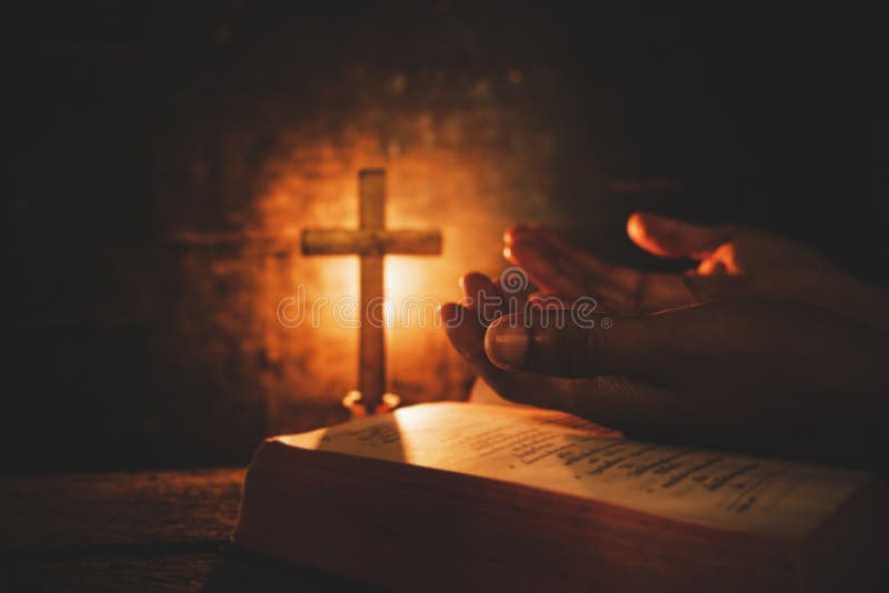 Vintage photo of hand with Bible praying , Hands folded in prayer on a Holy Bible