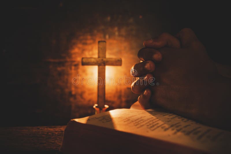 Vintage photo of hand with Bible praying , Hands folded in prayer on a Holy Bible