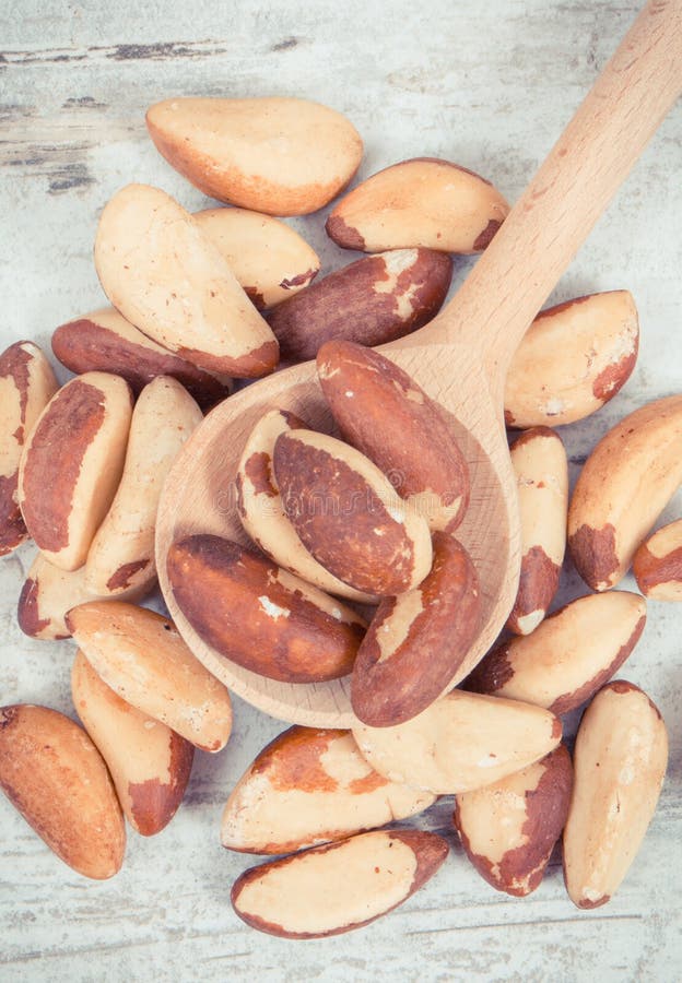 Vintage photo, Heap of brazil nuts with wooden spoon on rustic board stock image Vintage photo, Heap of brazil nuts with wooden spoon on rustic board stock image