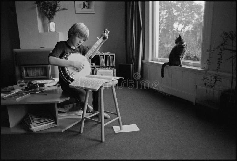 Vintage photo of a little boy that is practicing playing the banjo