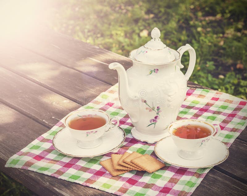 Vintage picture of tea cups and teapot on wooden t