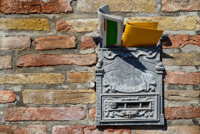Vintage Post Box with Newspaper and Letter on Old Brick Wall. Space for