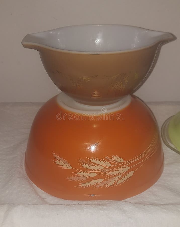 Vintage Pyrex Bows stacked one on top of upside down bowl 2 dufferent patterns orange brown