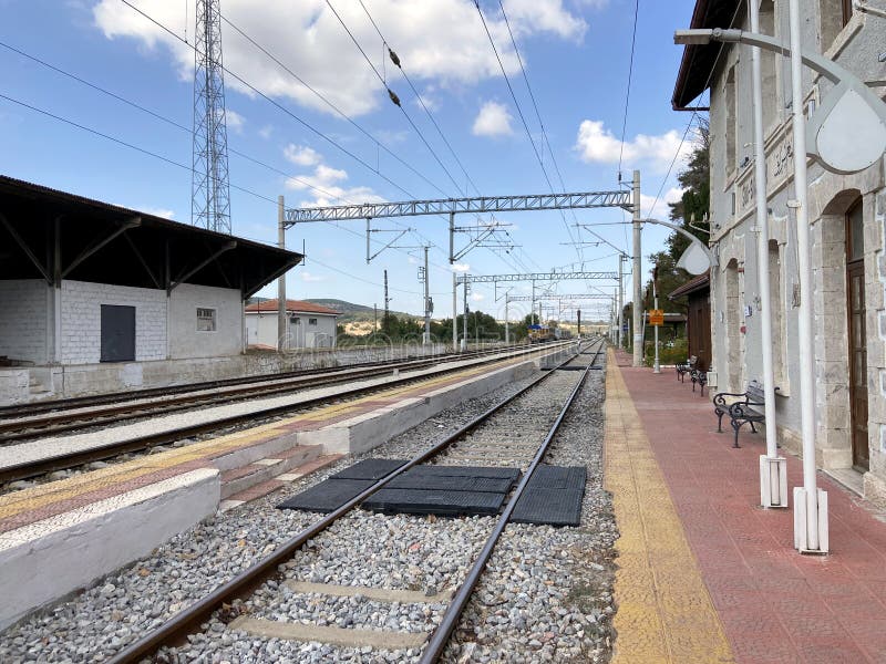 Vintage railroad tracks, steel railway for trains, sunny day on railway line with cloudy sky, old train station.